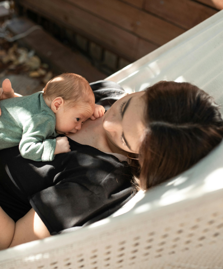 Mother laying in hammock with baby